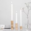 série de 3 bougeoirs totem avec chandelles allumées sur une table dressée