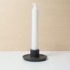 bougeoir en matière composite noir avec une chandelle blanche